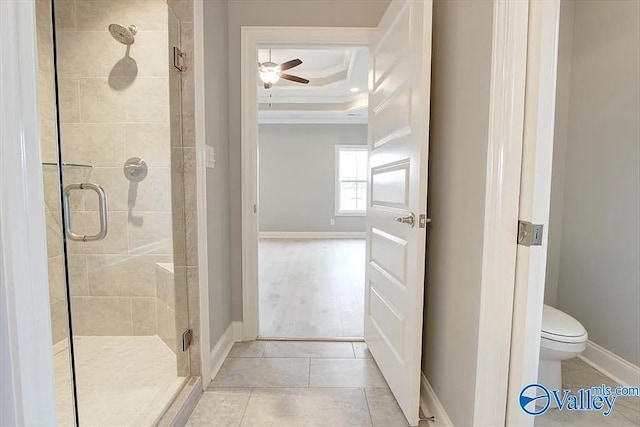 17401 Stonegate Dr, Athens, AL 35613 - bathroom with ornamental molding, a shower stall, a tray ceiling, a ceiling fan, and toilet