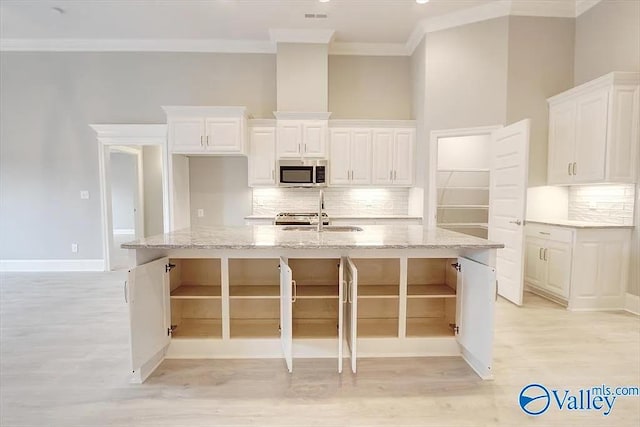17401 Stonegate Dr, Athens, AL 35613 - kitchen with stainless steel microwave, ornamental molding, a sink, light wood finished floors, and tasteful backsplash
