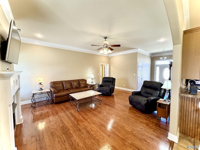 living area featuring light wood-style floors, a fireplace, baseboards, and ornamental molding