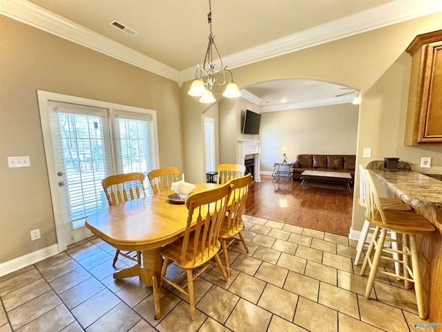 dining room featuring an inviting chandelier, baseboards, visible vents, and crown molding