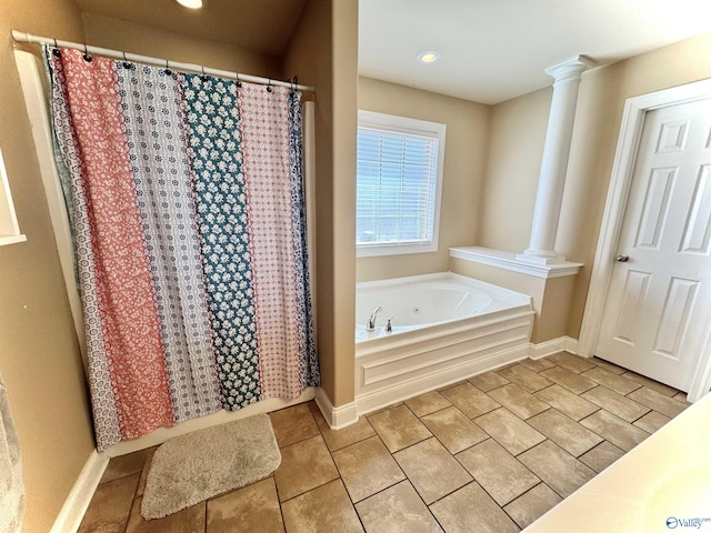 full bath featuring baseboards, tile patterned flooring, a garden tub, and ornate columns