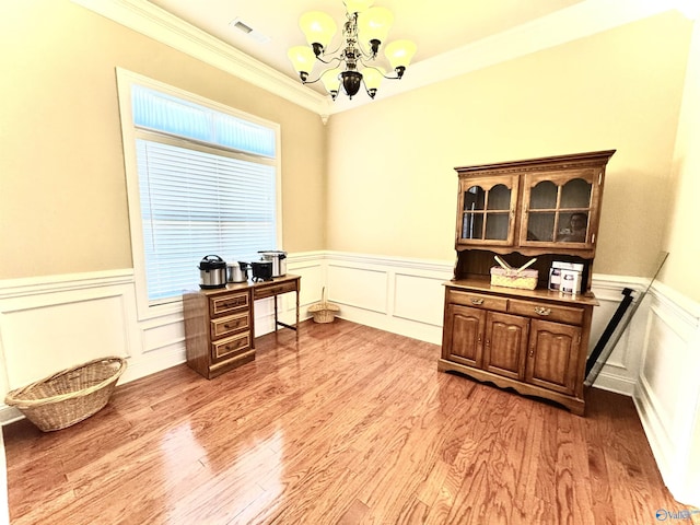 office area with a chandelier, a wainscoted wall, light wood-type flooring, and visible vents