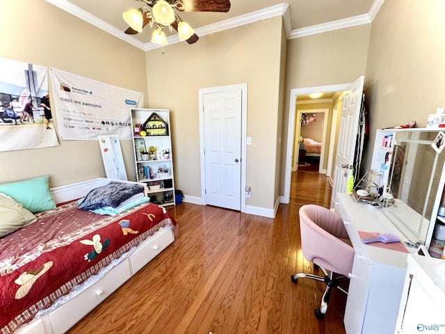 bedroom with baseboards, ornamental molding, and wood finished floors