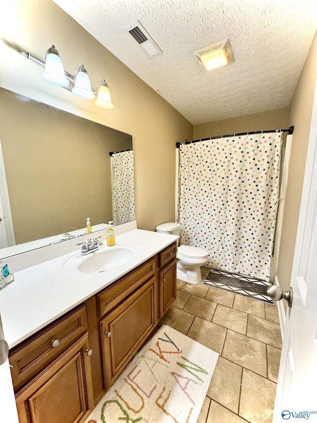 bathroom with toilet, visible vents, a textured ceiling, and vanity