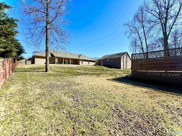 view of yard with fence and an outdoor structure