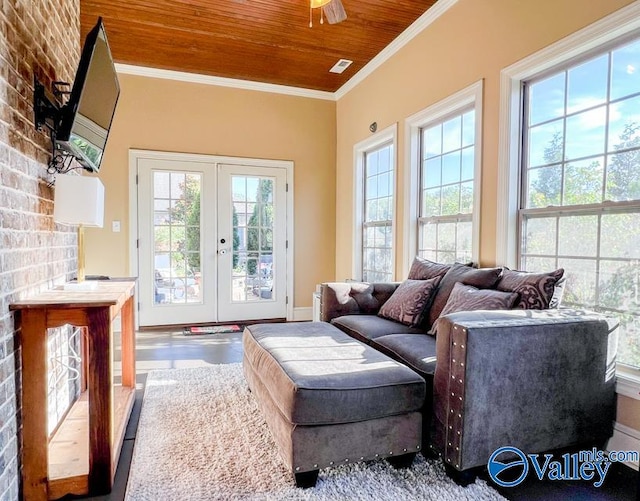 living room with crown molding, french doors, and brick wall