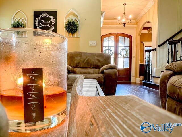 interior space with a notable chandelier, french doors, crown molding, and hardwood / wood-style floors