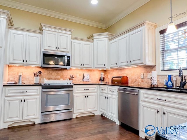 kitchen with decorative backsplash, pendant lighting, dark hardwood / wood-style flooring, and stainless steel appliances