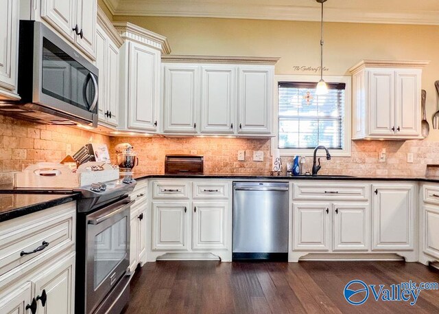 kitchen with decorative backsplash, appliances with stainless steel finishes, dark hardwood / wood-style flooring, and decorative light fixtures