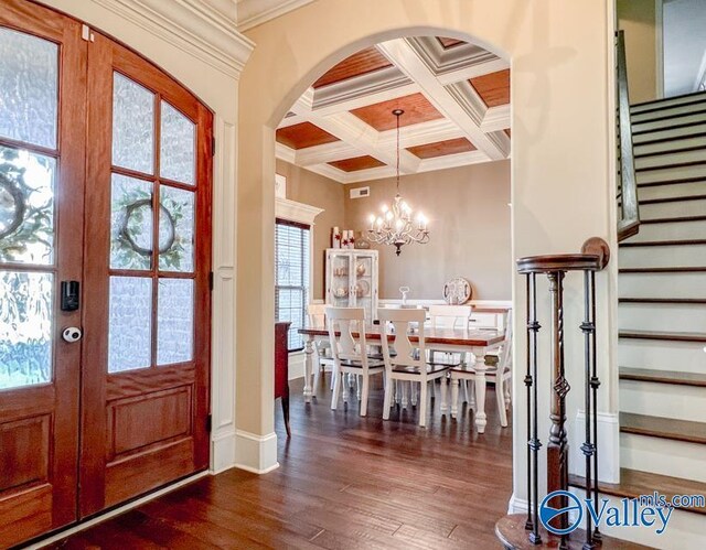 entrance foyer with a notable chandelier, french doors, dark hardwood / wood-style floors, beamed ceiling, and coffered ceiling