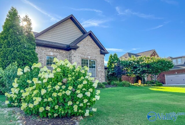 view of side of property featuring a garage and a lawn