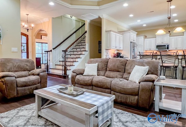 living room with ornamental molding, an inviting chandelier, and dark wood-type flooring