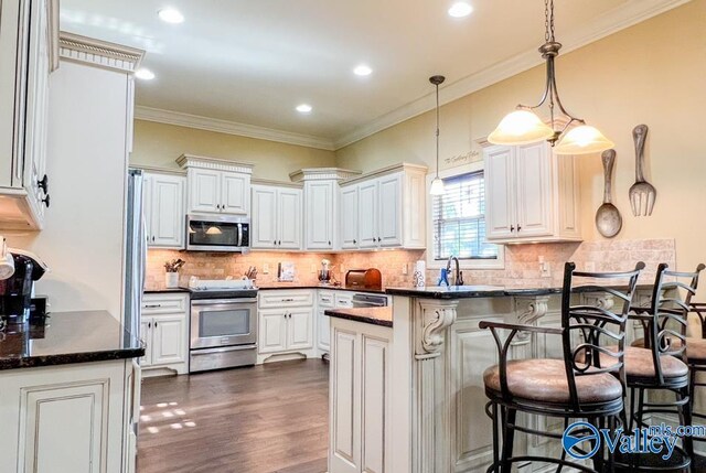 kitchen with appliances with stainless steel finishes, pendant lighting, backsplash, crown molding, and dark hardwood / wood-style floors