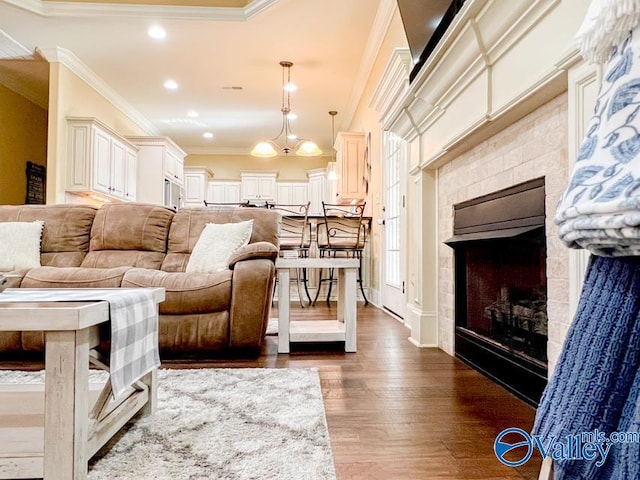 living room with a fireplace, wood-type flooring, and crown molding