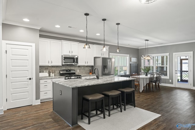 1530 Trek St NE, Huntsville, AL 35811 - kitchen featuring stainless steel appliances, dark wood-style floors, a kitchen island with sink, white cabinetry, and ornamental molding