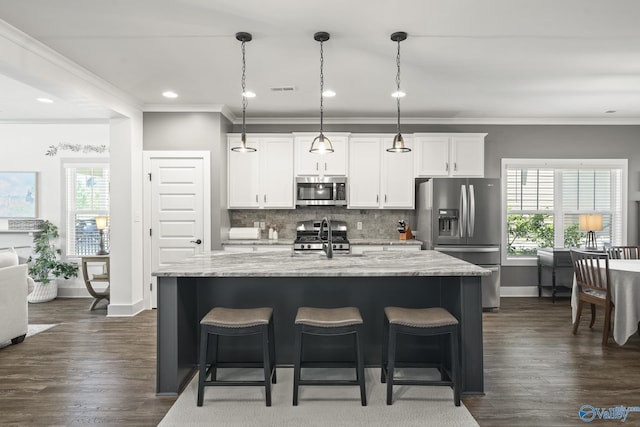 1530 Trek St NE, Huntsville, AL 35811 - kitchen with appliances with stainless steel finishes, a kitchen bar, healthy amount of natural light, ornamental molding, and recessed lighting