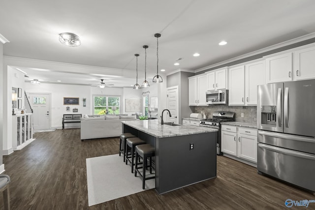 1530 Trek St NE, Huntsville, AL 35811 - kitchen featuring appliances with stainless steel finishes, crown molding, a sink, ceiling fan, and a kitchen breakfast bar