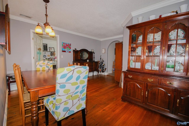 dining room featuring crown molding, dark hardwood / wood-style floors, and a textured ceiling