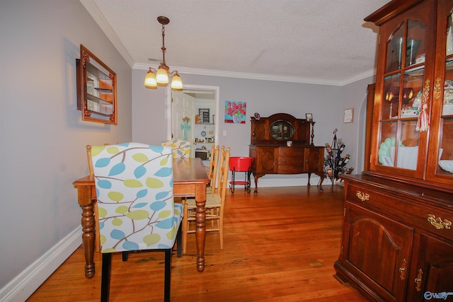 dining room with crown molding, hardwood / wood-style flooring, and an inviting chandelier