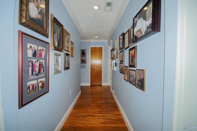 corridor featuring crown molding, a textured ceiling, and dark hardwood / wood-style flooring