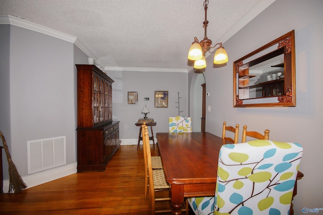 dining area with a notable chandelier, crown molding, a textured ceiling, and dark hardwood / wood-style flooring