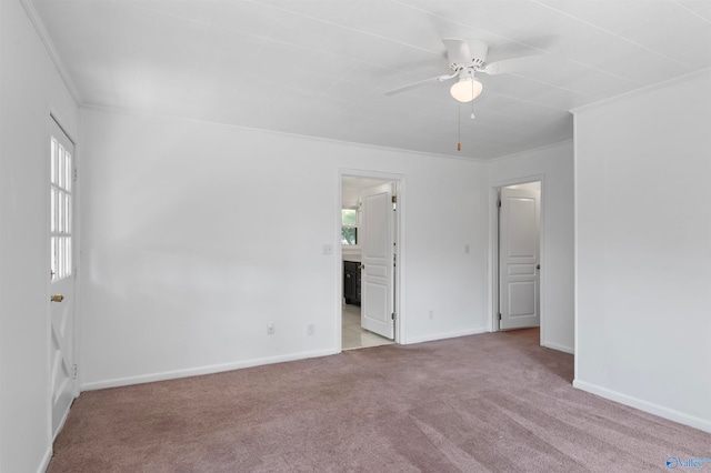 spare room featuring light carpet, crown molding, a healthy amount of sunlight, and ceiling fan