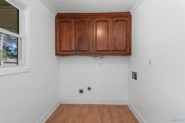 laundry room featuring washer hookup, light hardwood / wood-style floors, ornamental molding, and cabinets