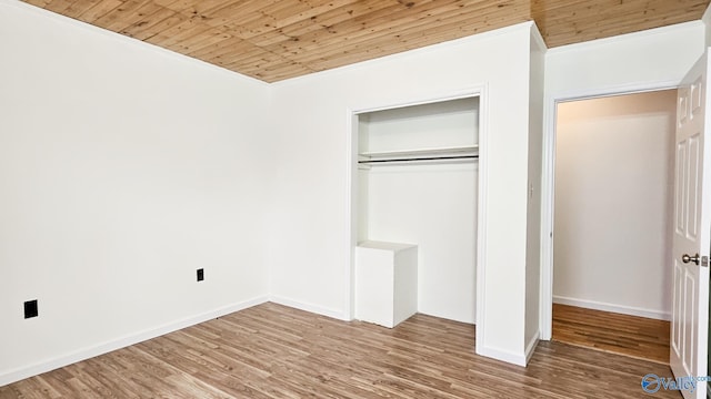 unfurnished bedroom with a closet, wood ceiling, baseboards, and wood finished floors