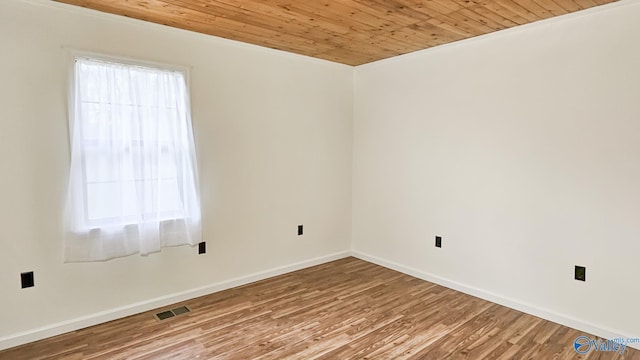 unfurnished room featuring visible vents, wood ceiling, baseboards, and wood finished floors