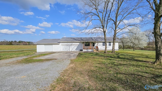 ranch-style house featuring gravel driveway and a front lawn