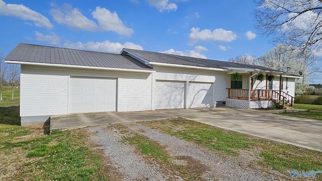 exterior space with a garage, metal roof, and driveway