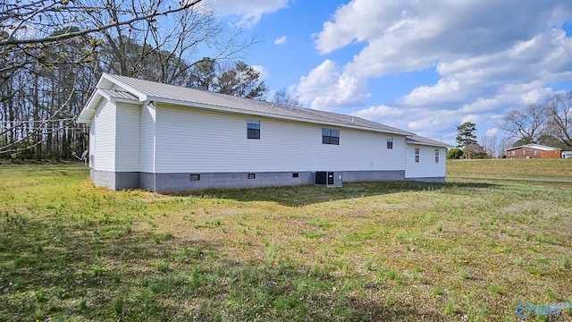 rear view of house featuring central AC unit, metal roof, and a yard