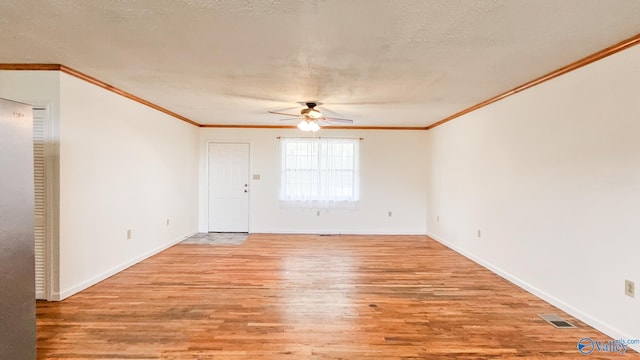 unfurnished room with light wood-type flooring, visible vents, ornamental molding, and a ceiling fan