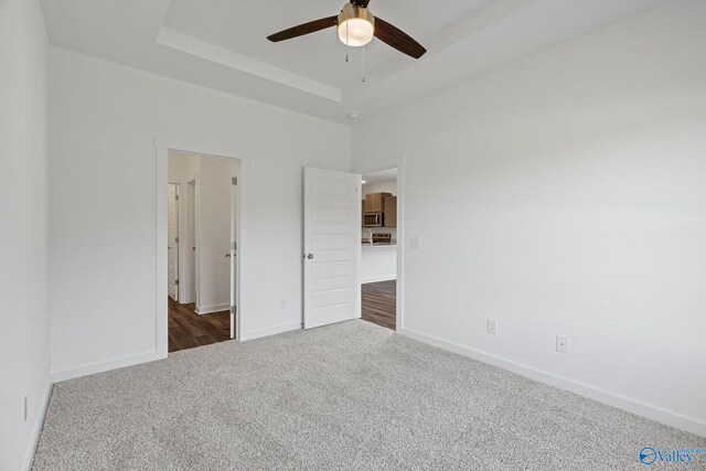6219 Taramore Ln NW, Huntsville, AL 35806 - unfurnished bedroom with ceiling fan, baseboards, dark carpet, and a raised ceiling