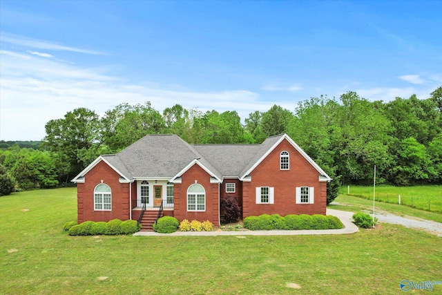 view of front of house featuring brick siding and a front yard