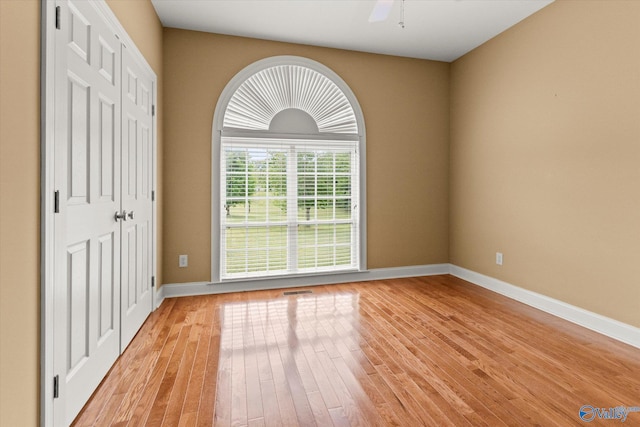 spare room with light wood-style flooring, baseboards, and a ceiling fan