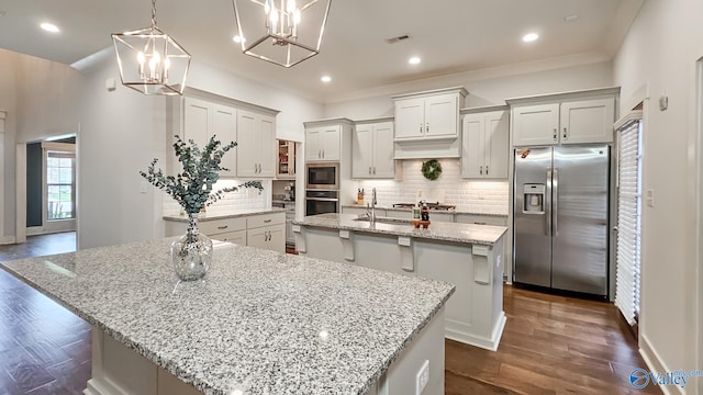 17583 Maree Dr, Athens, AL 35613 - kitchen featuring a notable chandelier, a center island with sink, visible vents, backsplash, and appliances with stainless steel finishes