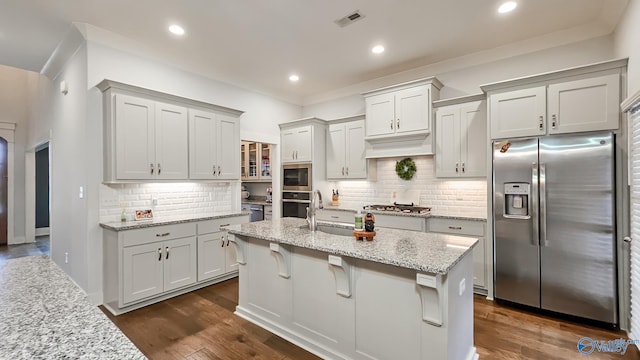 17583 Maree Dr, Athens, AL 35613 - kitchen with a sink, a center island with sink, backsplash, light stone countertops, and appliances with stainless steel finishes