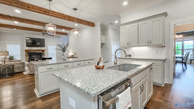 17583 Maree Dr, Athens, AL 35613 - kitchen featuring a sink, ceiling fan with notable chandelier, dishwasher, a fireplace, and an island with sink