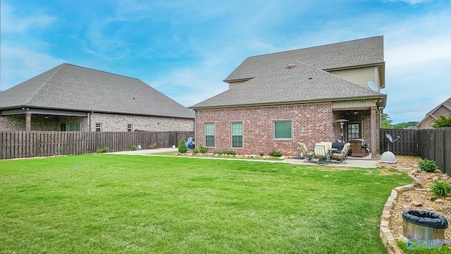 17583 Maree Dr, Athens, AL 35613 - back of property featuring a lawn, a fenced backyard, a patio area, roof with shingles, and brick siding