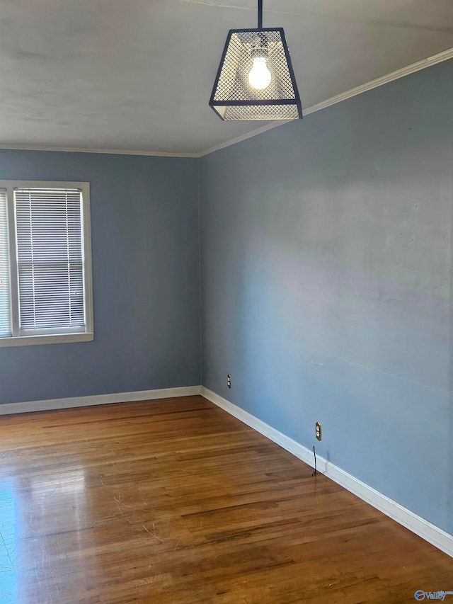 empty room featuring crown molding and hardwood / wood-style floors