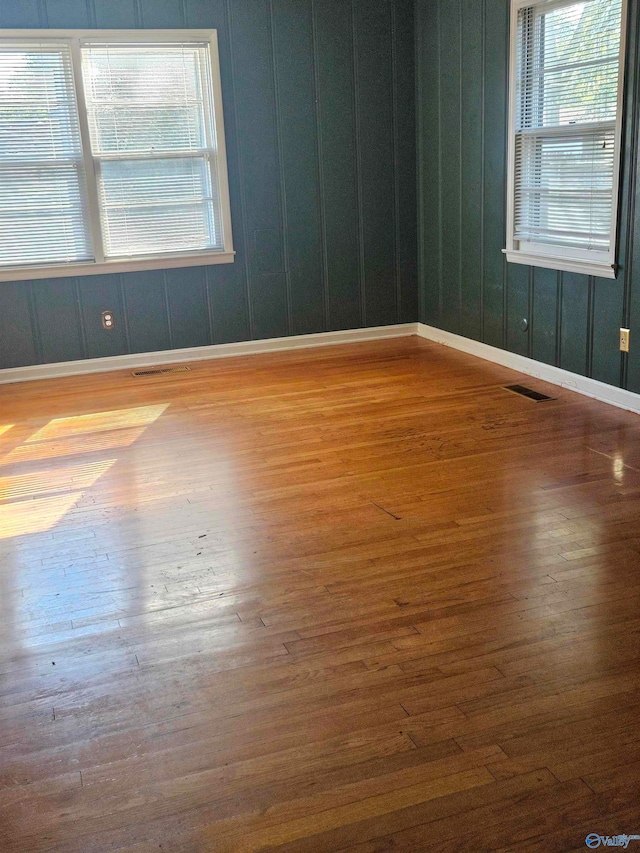 spare room featuring hardwood / wood-style floors and a healthy amount of sunlight