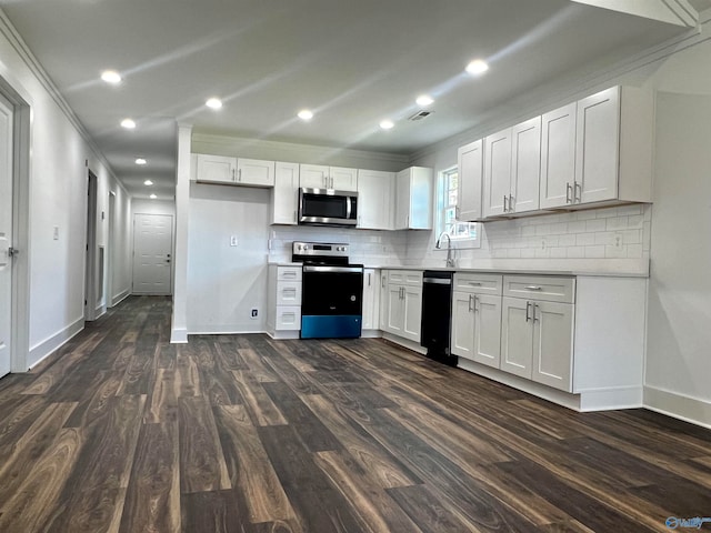 kitchen featuring ornamental molding, white cabinetry, stainless steel appliances, and dark hardwood / wood-style flooring