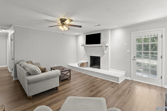 3374 Old Moulton Rd SW, Decatur, AL 35603 - living room with a ceiling fan, wood finished floors, a textured ceiling, and a brick fireplace
