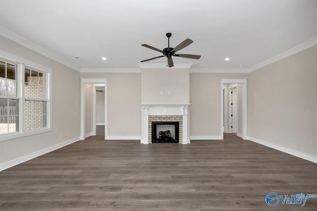 unfurnished living room featuring ceiling fan, ornamental molding, dark hardwood / wood-style floors, and a brick fireplace