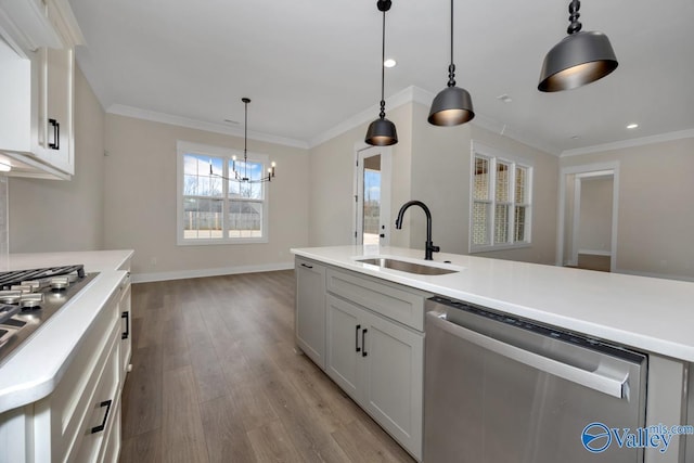 kitchen with sink, appliances with stainless steel finishes, hanging light fixtures, light hardwood / wood-style floors, and white cabinets