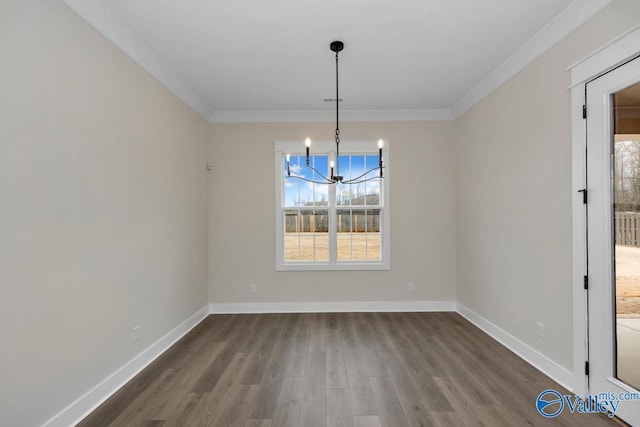 unfurnished dining area with a notable chandelier, dark wood-type flooring, and ornamental molding