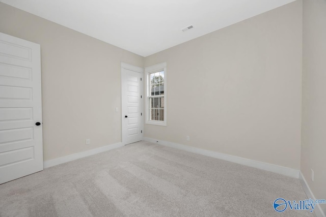 unfurnished room featuring light carpet