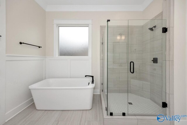 bathroom with ornamental molding and separate shower and tub