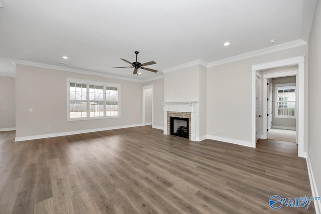 unfurnished living room featuring dark hardwood / wood-style flooring, a fireplace, ornamental molding, and ceiling fan